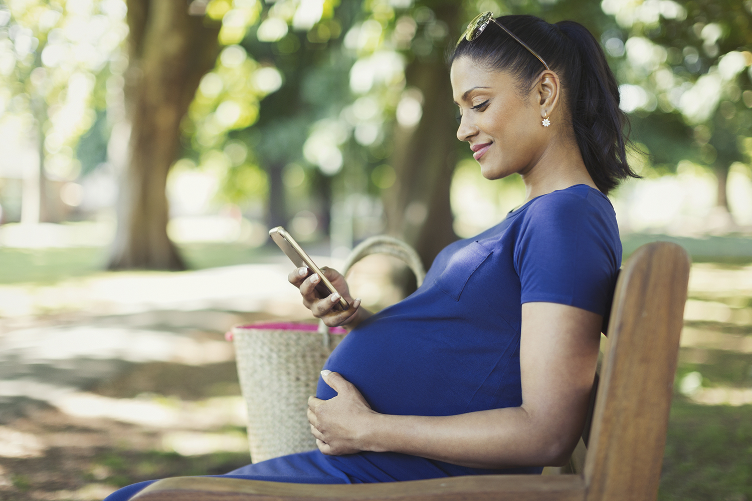 pregnant woman on phone in park