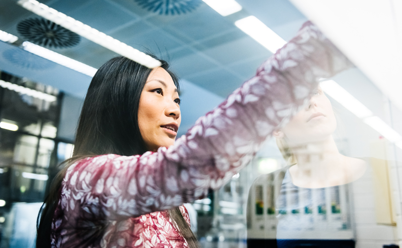 young woman looking at her work with colleague 